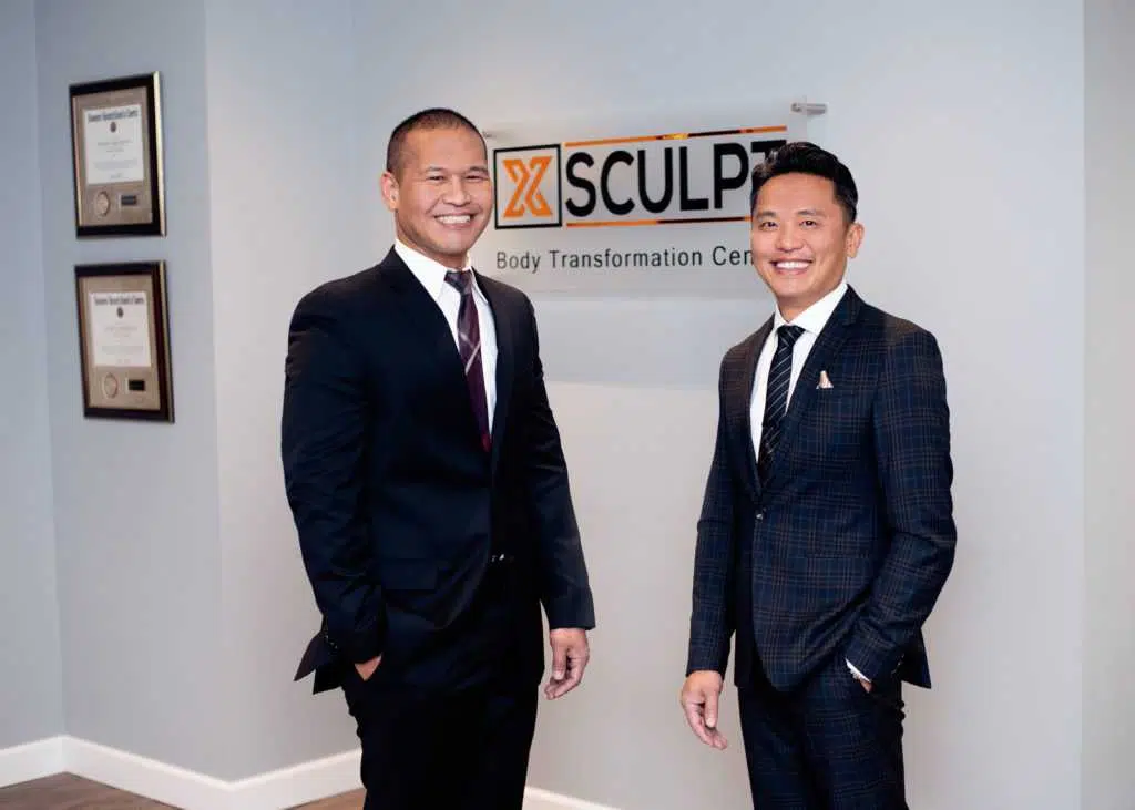 Two men in suits standing in front of the xsculp logo showcasing renuvion technology.