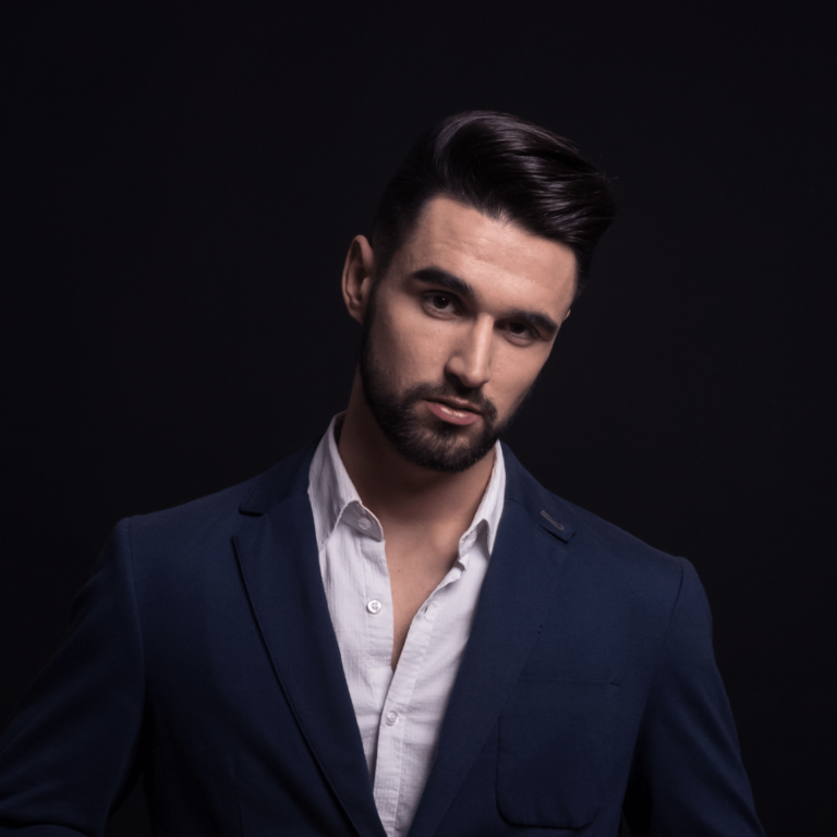 Can TRT Cause Gynecomastia? What Every Man Should Know 10 A man in a blue suit posing on a black background with permanent hair transplant.